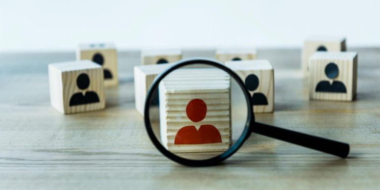 a magnifier and cubes with the silhouette of different candidates