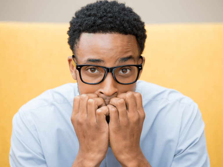 Employee suffering from return to work anxiety, slouched and biting his nails