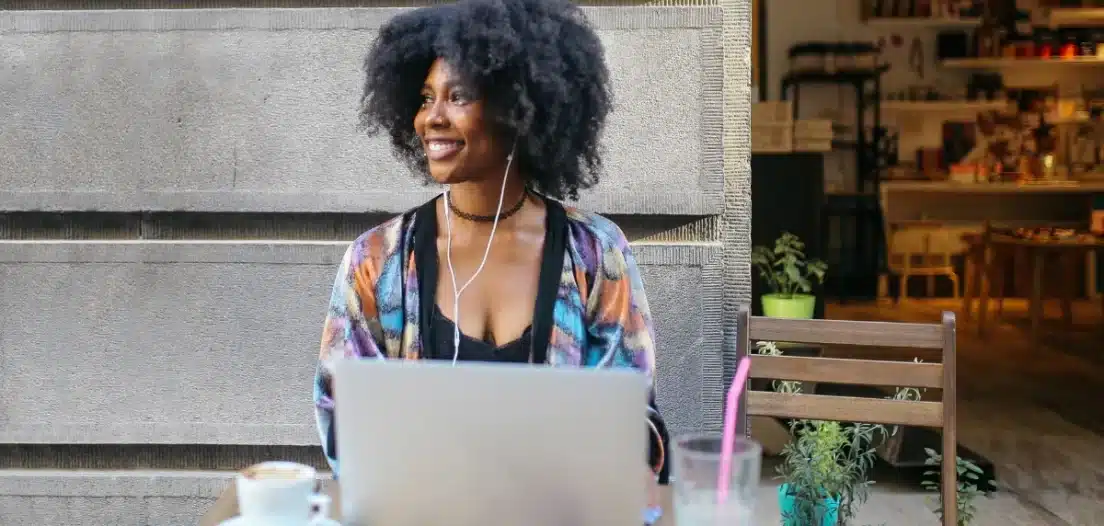 A black woman living and working abroad thanks to a digital nomad visa works from a local cafe