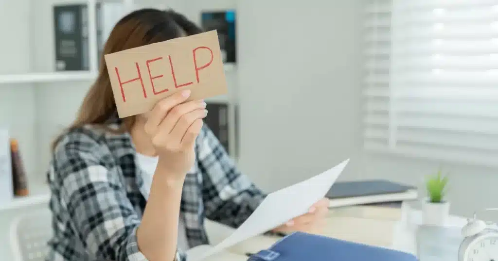 A woman at her home desk feeling overwhelmed, not having a clear Job Search Plan