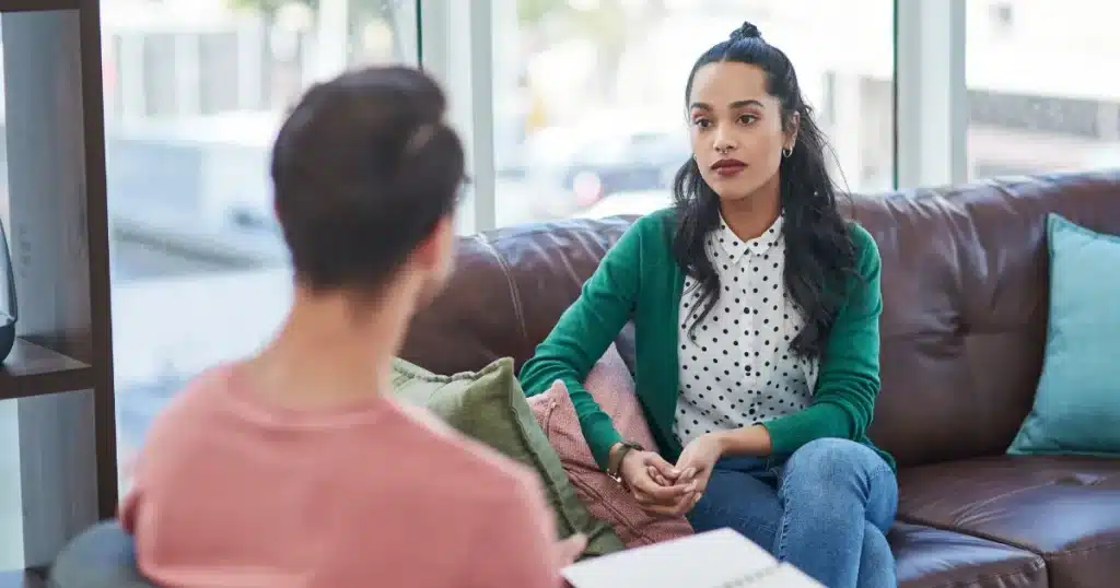 A young woman listens and pays attention to her colleague, a man, who's introducing her to her new role