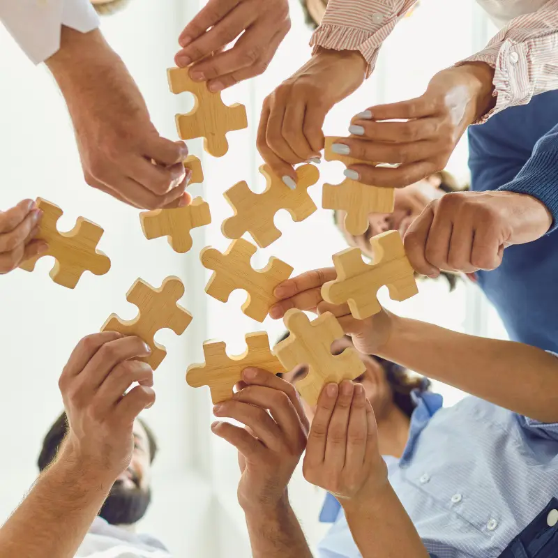 A group of people hold the pieces of a puzzle