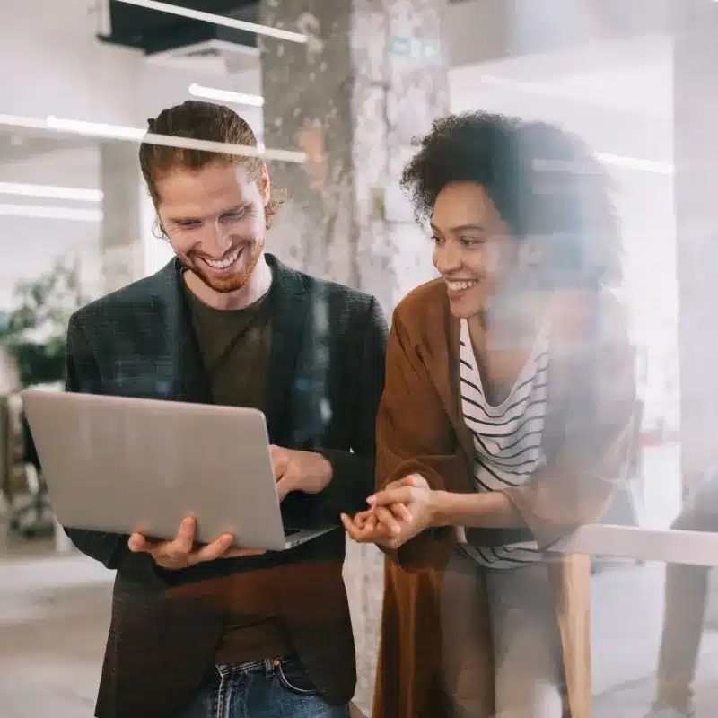 A woman and a man smile after receiving an excellent client feedback