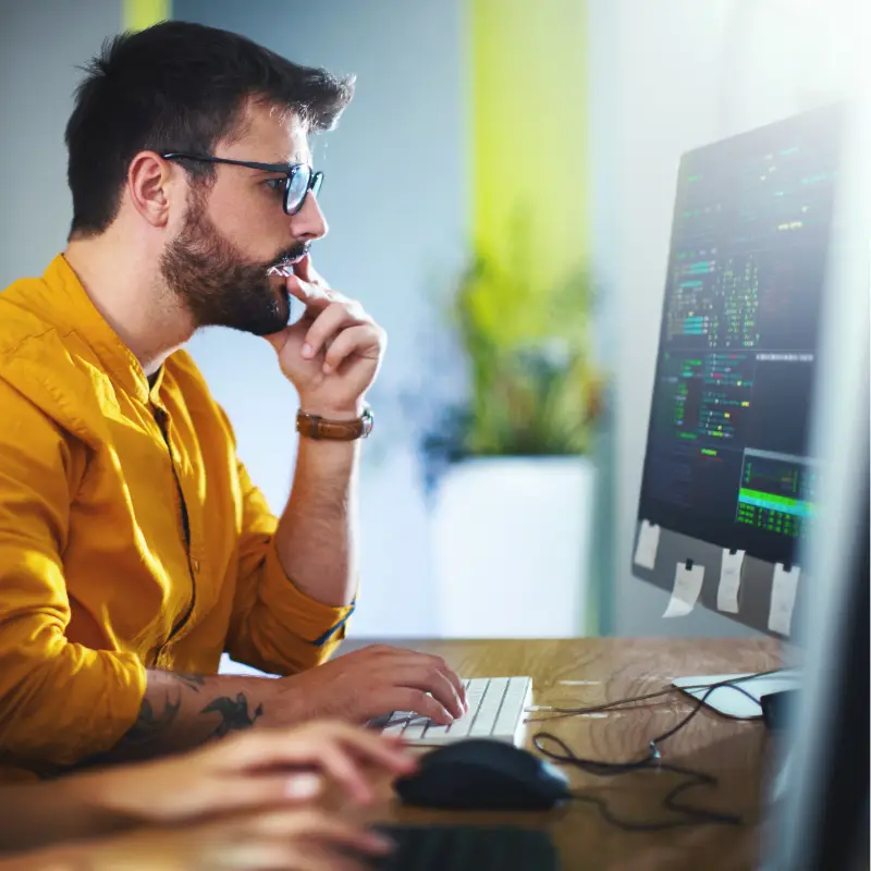 An IT Engineer works on a computer. He's focused on his job