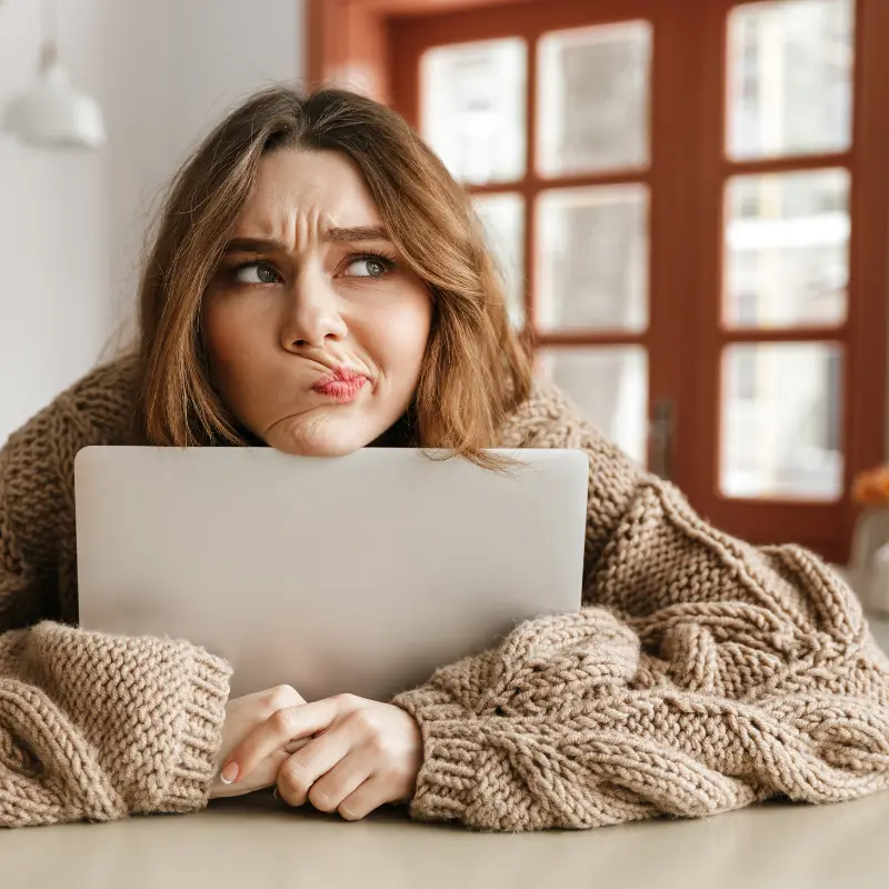 A young woman holds her laptop, wondering about the future of her career as a software engineer